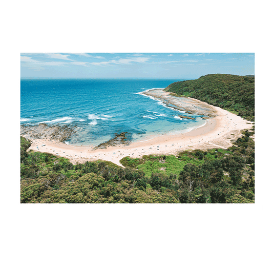 A stunning aerial view of Bateau Bay, NSW, showcasing golden sand, turquoise ocean waves, and people enjoying a sunny beach day. The lush green headland contrasts with the vibrant blue waters, creating a perfect coastal scene.
