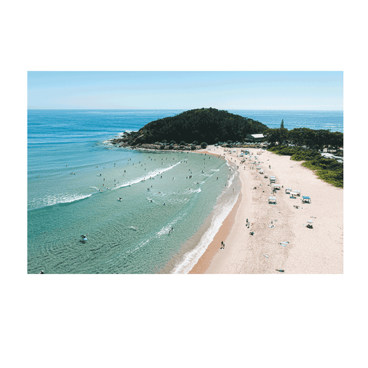 A vibrant beachside scene at Scotts Head, NSW, showcasing golden sands, turquoise waters, and beachgoers enjoying a warm summer day. Gentle waves roll onto the shore as swimmers and surfers embrace the coastal lifestyle.
