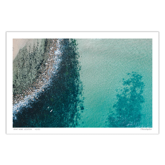 Aerial view of Avoca Beach, NSW, where the rocky shoreline meets the crystal-clear turquoise waters, creating a stunning coastal contrast