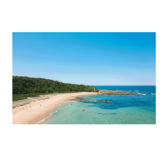 Aerial view of Bateau Bay, NSW, featuring golden sands, turquoise waters, and lush greenery along the coastline.