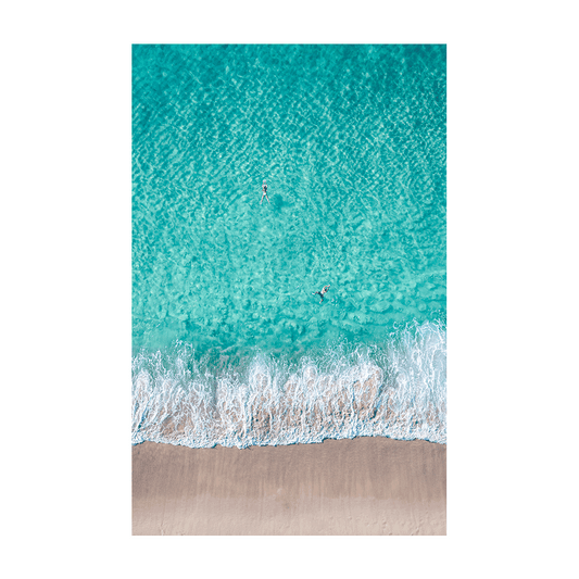 A stunning aerial view of Bronte Beach, Sydney, featuring swimmers floating in turquoise waters as waves meet the sandy shore.