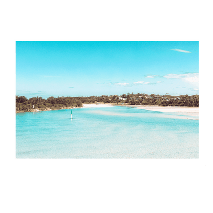 Scenic view of Broulee on the South Coast of NSW, featuring crystal-clear turquoise waters, golden sandbanks, and lush coastal greenery under a bright blue sky.