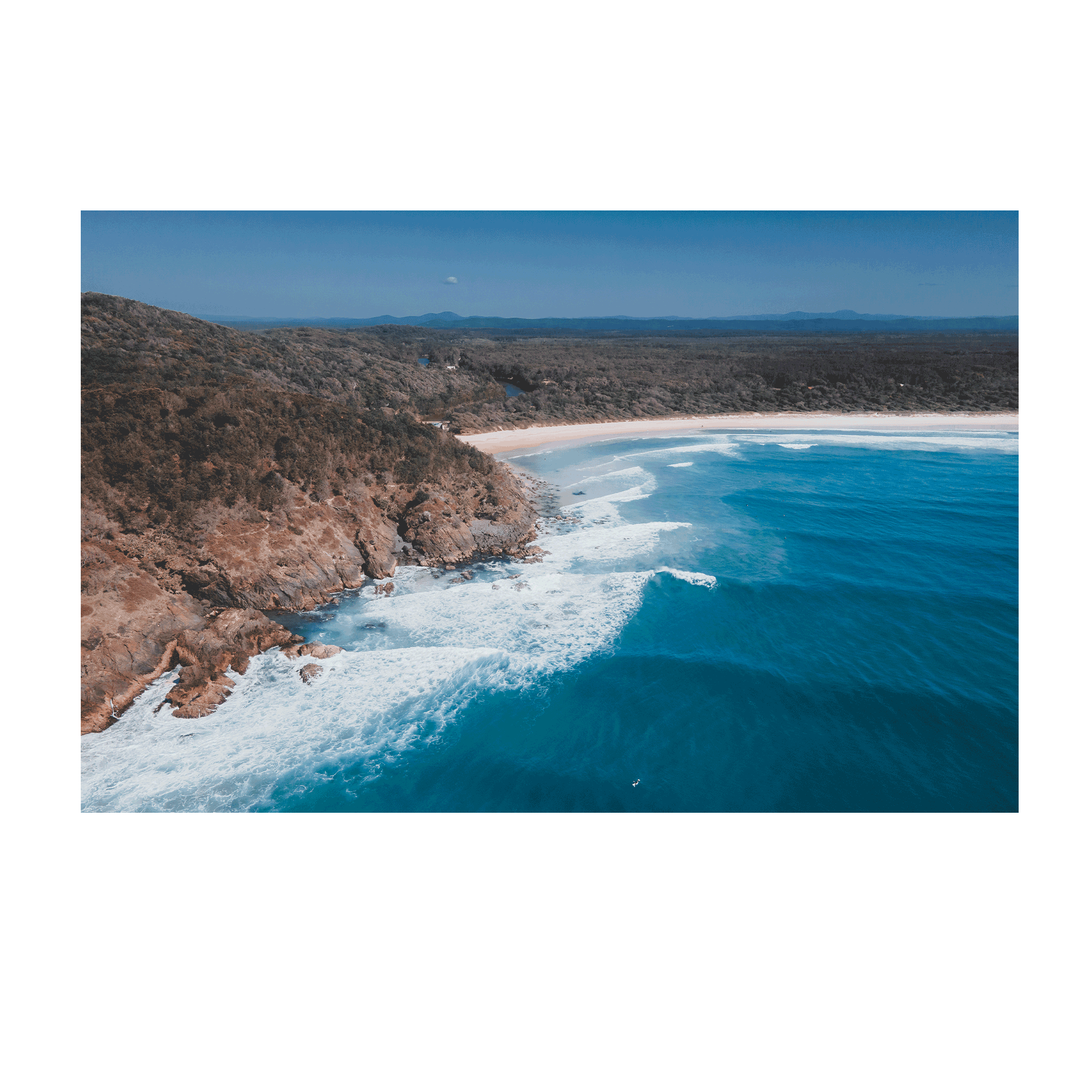 An aerial coastal print of Big Hill Beach, Crescent Head, NSW, featuring rugged cliffs, golden sand, and deep blue ocean waves crashing along the shoreline.
