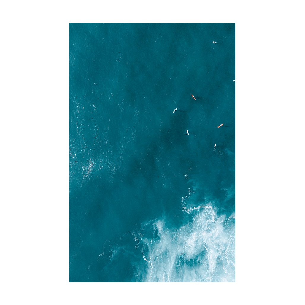 Aerial view of waves swirling over golden sands at Forresters Beach, NSW, creating a dynamic and abstract ocean scene.
