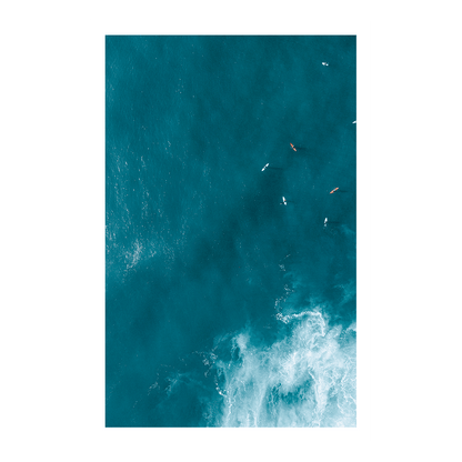 Aerial view of waves swirling over golden sands at Forresters Beach, NSW, creating a dynamic and abstract ocean scene.
