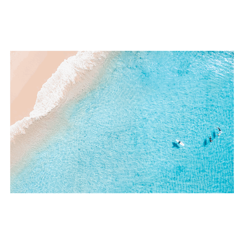 A stunning aerial beach print of Forresters Beach, NSW, featuring pastel sands, clear blue waters, and surfers floating in the shallows.