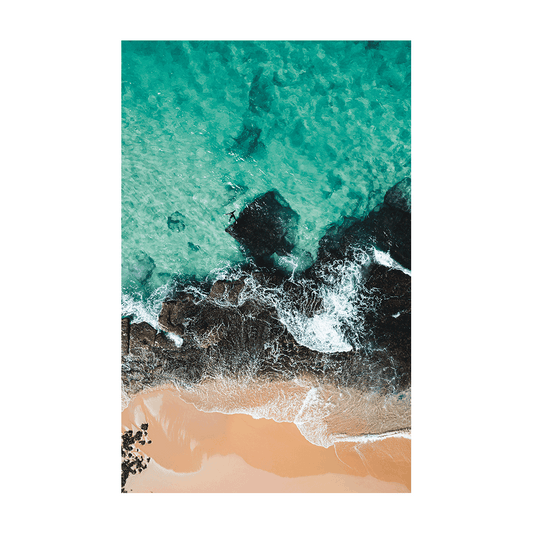 Aerial view of Forresters Beach, NSW, showing turquoise ocean waves crashing against dark coastal rocks and golden sand.
