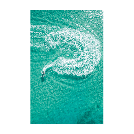 A jet ski carving a perfect swirl in the turquoise waters off Frazer Beach, NSW, leaving a foamy white trail.
