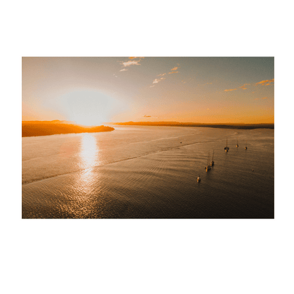 A golden sunset over calm waters in Illuka, North Coast, NSW, with boats peacefully resting in the bay.
