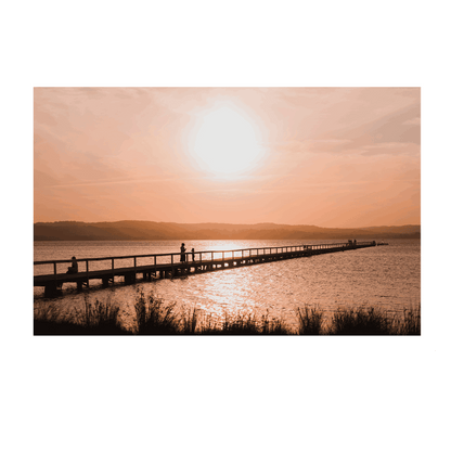 A stunning sunset at Long Jetty, NSW, with silhouettes walking along the boardwalk as golden light reflects on the water.