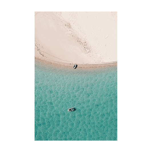 A stunning aerial view of Nambucca Beach, NSW, featuring two boats floating on turquoise waters near untouched sand dunes.