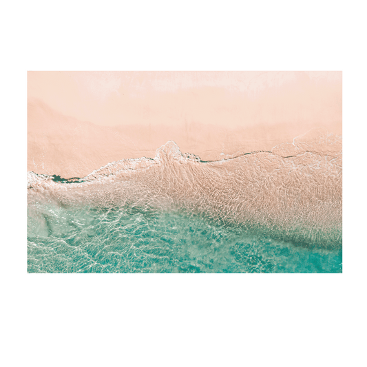 A soft aerial coastal scene at Norah Head, NSW, showcasing the gentle transition between sandy beach and clear aqua ocean waters.
