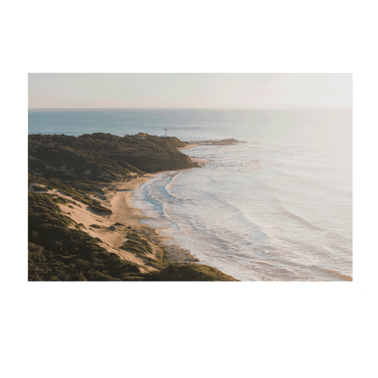 A soft, misty aerial view of Norah Head, NSW, featuring rolling sand dunes, a rugged coastline, and gentle ocean waves bathed in morning light.