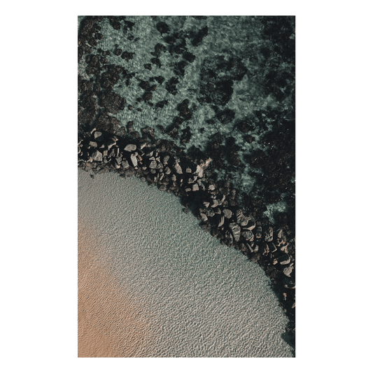 Aerial view of Soldiers Beach, NSW, featuring rugged rock formations meeting the crystal-clear waters and golden sand.