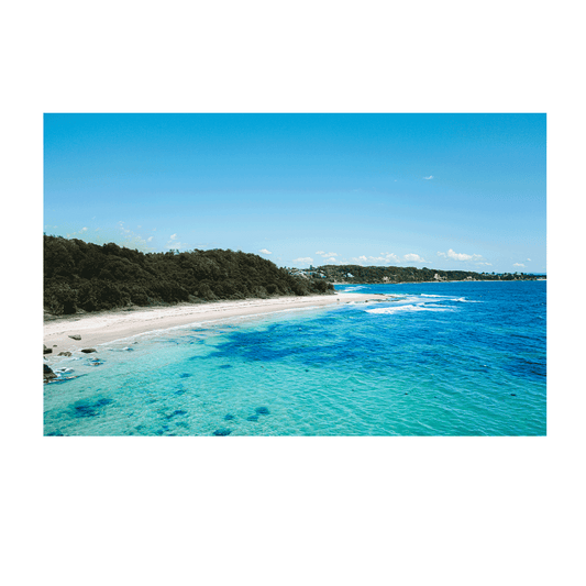 A breathtaking aerial view of Norah Head, NSW, showcasing turquoise waters, golden sand, and lush greenery.