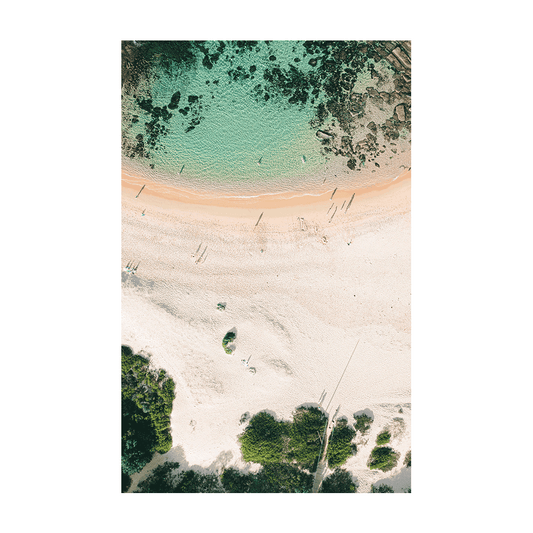 An aerial view of Spoon Bay, Central Coast, featuring turquoise waters, golden sands, and lush greenery with intricate rock formations beneath the surface.