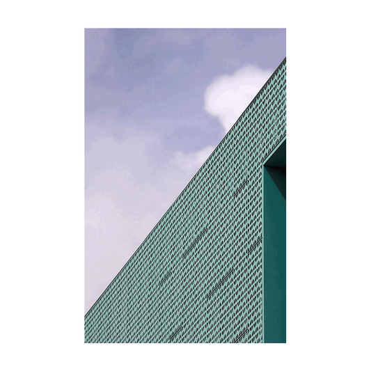 A modern architectural facade in Sydney featuring a geometric perforated design with sharp angles against a soft sky.