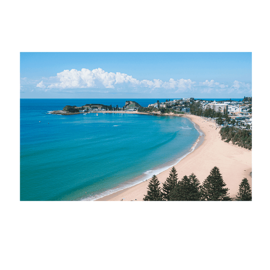 An aerial view of Terrigal Beach, NSW, showcasing golden sand, turquoise ocean waves, and a picturesque coastal town with lush green surroundings.
