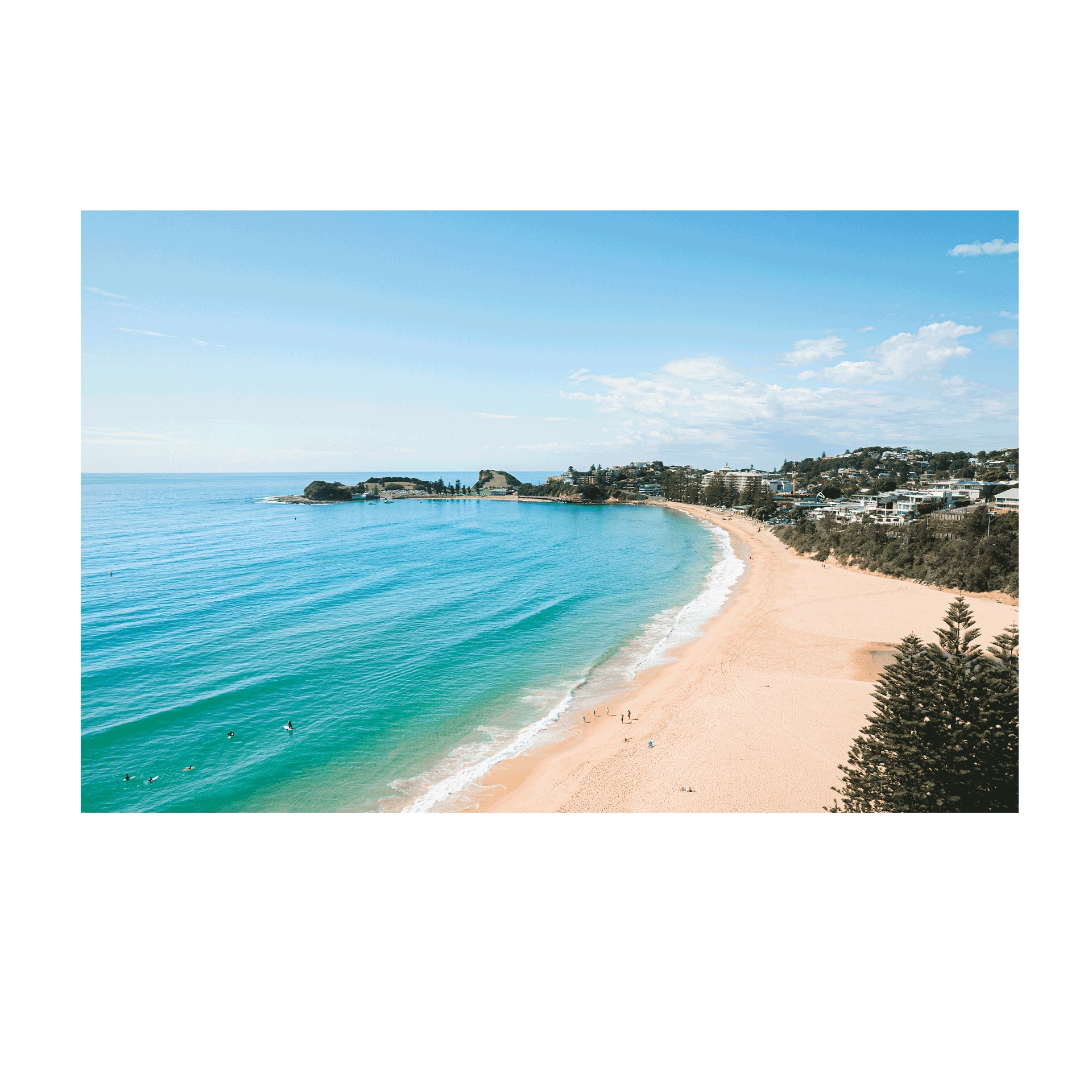 An aerial view of Terrigal Beach, NSW, showing golden sand, turquoise ocean waves, and swimmers enjoying the water on a sunny day.
