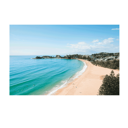 An aerial view of Terrigal Beach, NSW, showing golden sand, turquoise ocean waves, and swimmers enjoying the water on a sunny day.
