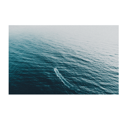 Aerial view of a vast deep blue ocean with a single vessel leaving a gentle wake behind, creating a sense of solitude and serenity.