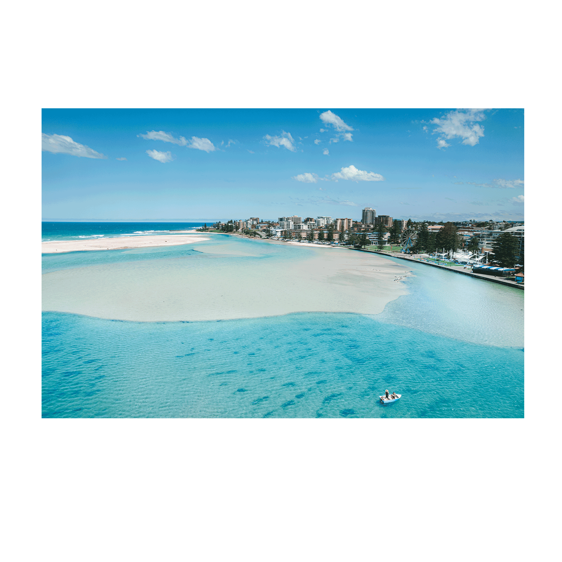 A stunning aerial print of The Entrance, NSW, featuring a small boat drifting on turquoise waters near golden sandbanks, with a scenic coastal backdrop.
