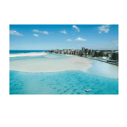 A stunning aerial print of The Entrance, NSW, featuring a small boat drifting on turquoise waters near golden sandbanks, with a scenic coastal backdrop.
