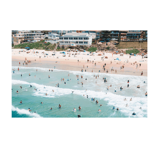 A vibrant aerial print of The Entrance Beach, NSW, featuring a packed shoreline with beachgoers in the waves and on the sand, capturing the energy of a perfect summer day.
