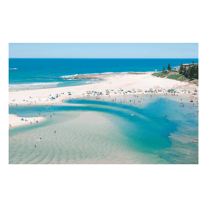 A stunning aerial print of The Entrance, NSW, featuring golden sands, turquoise waters, and vibrant umbrellas lining the shoreline on a perfect summer’s day.