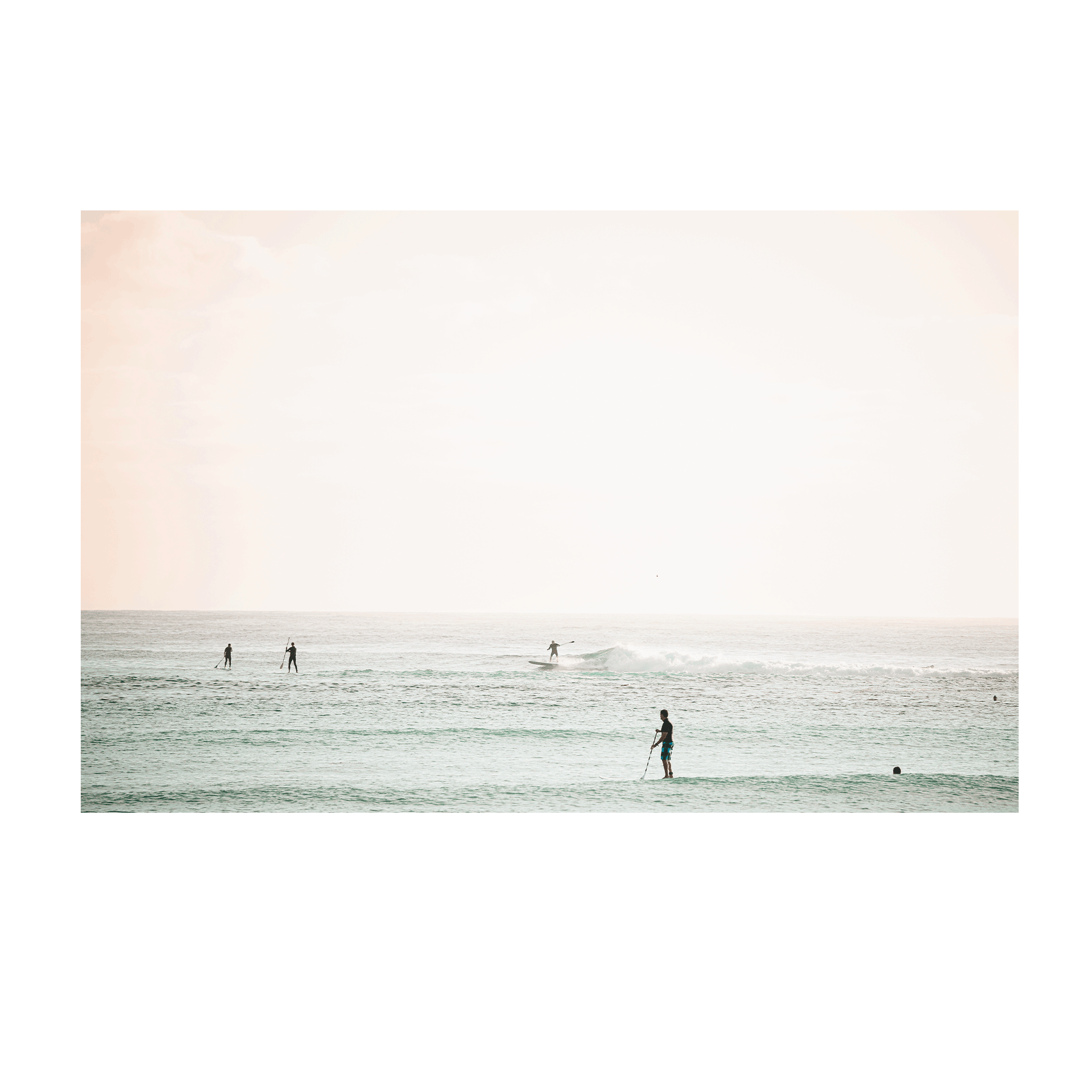 A serene coastal scene of Toowoon Bay Beach, featuring paddleboarders and surfers gliding across pastel-hued waters. A soft, minimalist ocean print perfect for adding a calming beachside aesthetic to any space.
